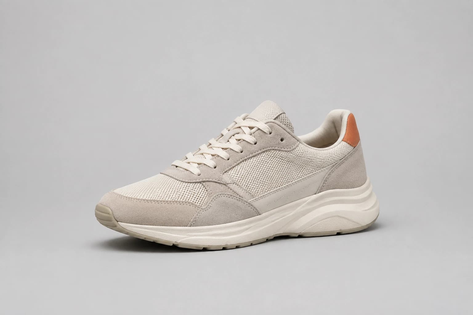 Ivory running shoe photographed against a plain grey studio background